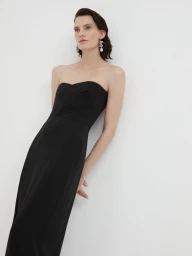 Model wearing a black strapless midi dress against a plain white studio background.