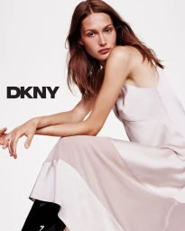 Model wearing a light pink sleeveless dress against a solid white background with the DKNY logo