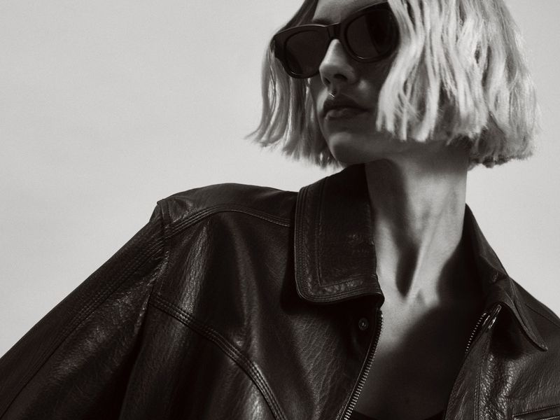 Model in dark sunglasses and a black leather jacket against a light background for Nour Hammour Spring Summer 25.
