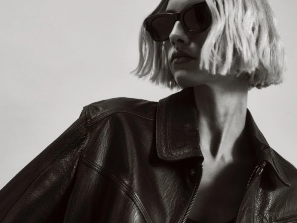 Model in dark sunglasses and a black leather jacket against a light background for Nour Hammour Spring Summer 25.