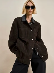 Model wearing dark sunglasses and a dark brown leather jacket against a plain neutral background.