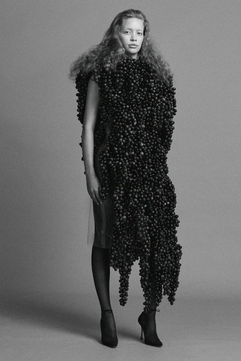 Model Ella Dalton wearing a sculptural garment covered in dark grapes for Ponte F/W 25 Lookbook