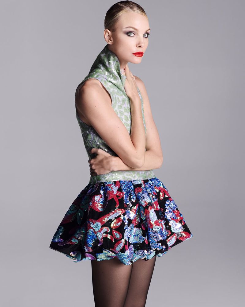 Caroline Trentini wearing 16Arlington featuring a green patterned top and voluminous sequin skirt against a grey background.