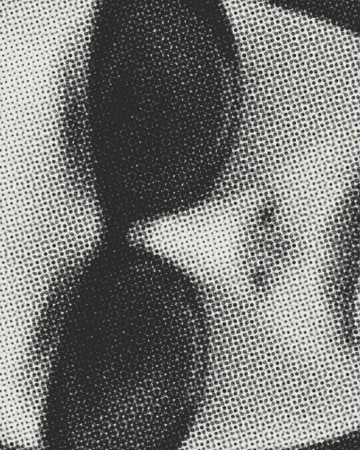 Monochromatic image featuring a close-up of a surface with a halftone pattern in varying shades of gray, creating an abstract visual.
