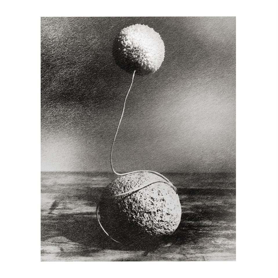 Monochrome image of two spherical objects connected by a thin wire on a textured surface, with a dark, mottled background. Artful and simple.