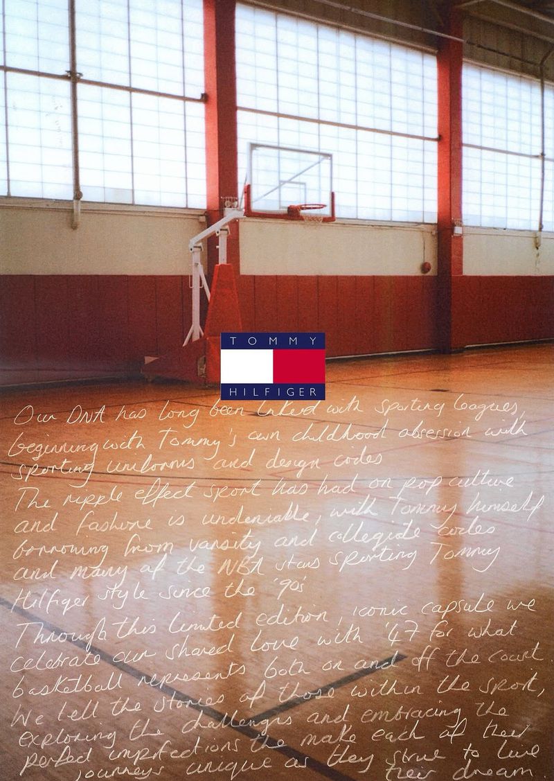Indoor basketball court featuring a backboard, Tommy Hilfiger logo, and white text on a wooden floor, creating a vintage sports aesthetic.