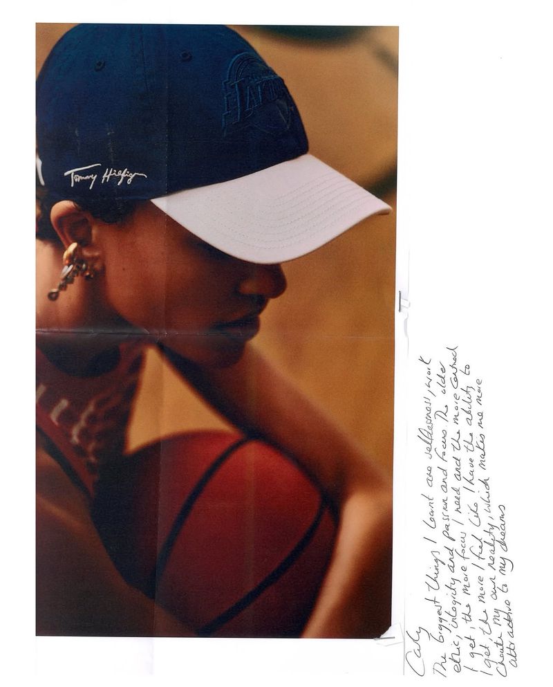 Model wearing a navy baseball cap with white brim and holding a basketball for Tommy Hilfiger project 47 Caps for Tommy.