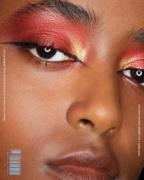 Close-up portrait of a woman with vibrant red and gold eyeshadow and winged eyeliner for The Chanel Cometes Collective