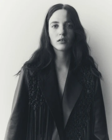 Portrait of female model Julia Banas wearing a dark jacket against a plain white background for Lafayette 148