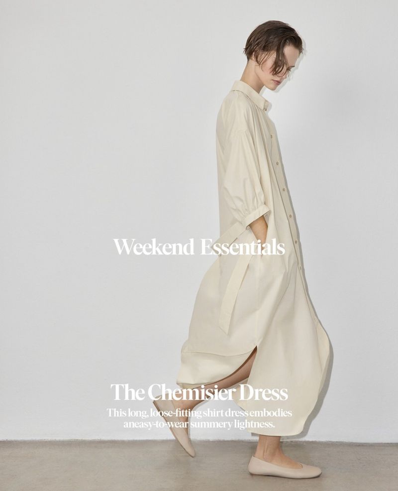 Adult female model in a beige, loose-fitting shirt dress and flat shoes, walking in a photo studio with white background, fashion photography.