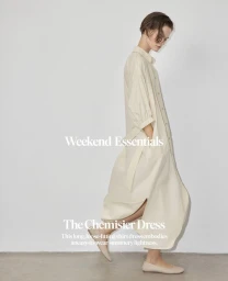 Model wearing a loose cream shirt dress and flats standing against a plain white studio background