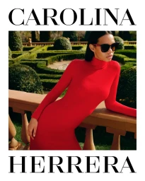 Model wearing a red turtleneck dress and dark sunglasses leans against a stone balustrade in a formal garden.