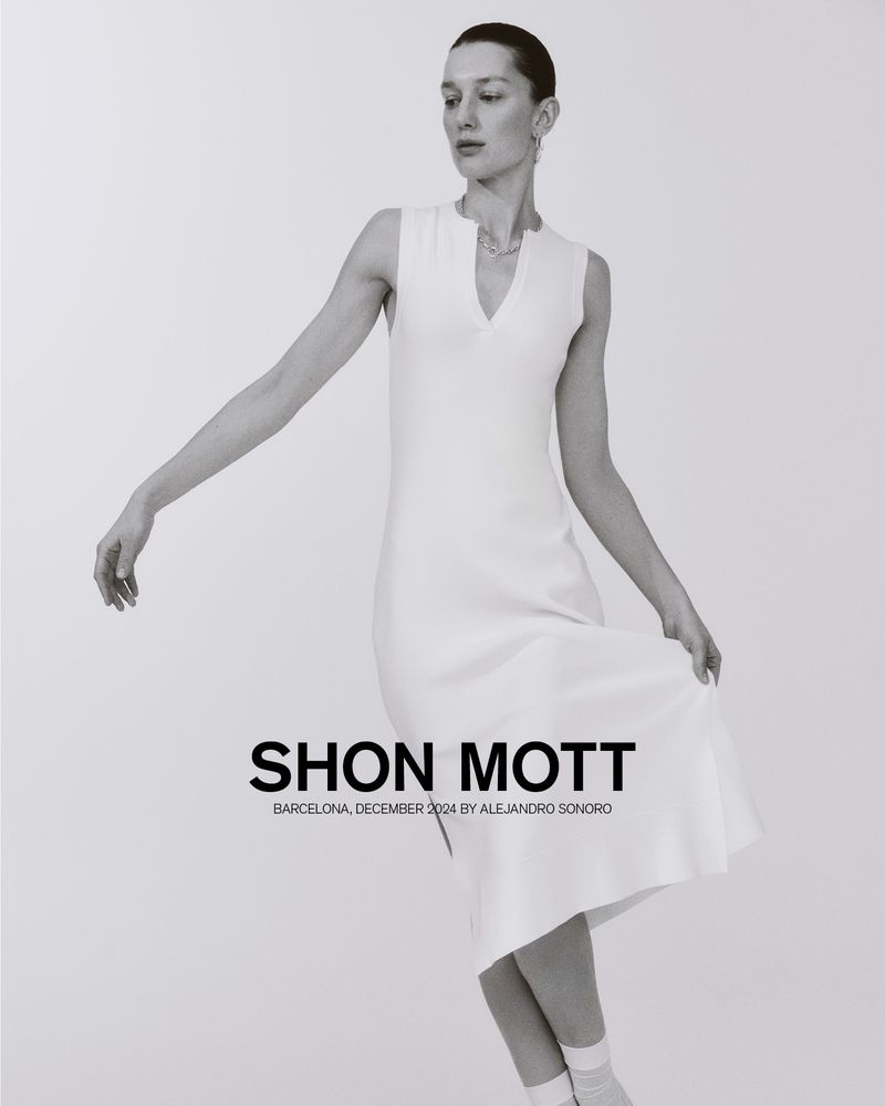 Elegant woman in flowing white midi-dress in a light, bright, neutral studio. Fashion photography featuring a sleeveless dress.