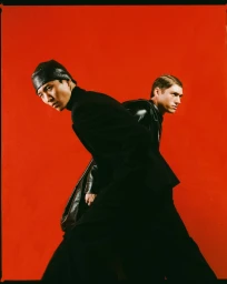 Two male models posing against a vibrant red background for the 032c Winter Collection NIGHTHAWKS campaign.