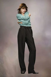 Model wearing a textured mint green knit sweater, dark trousers, and a brown velvet hat against a neutral backdrop.