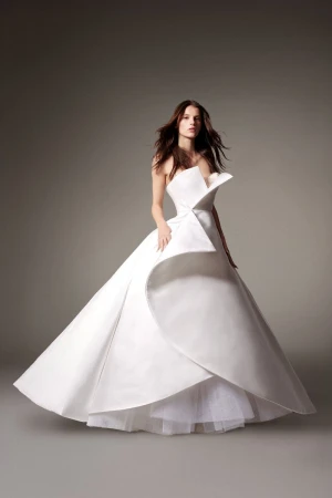 Elegant adult woman in a white strapless gown in a studio setting with soft lighting; showcasing couture fashion.