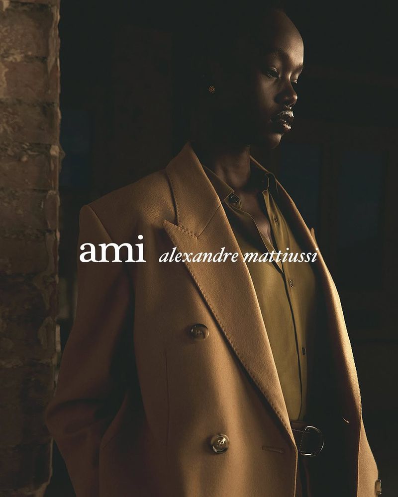 A striking fashion shot of an African woman in a tan blazer and olive shirt, showcasing a blend of urban style and classic elegance.