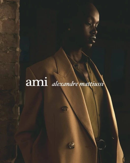 A striking fashion shot of an African woman in a tan blazer and olive shirt, showcasing a blend of urban style and classic elegance.