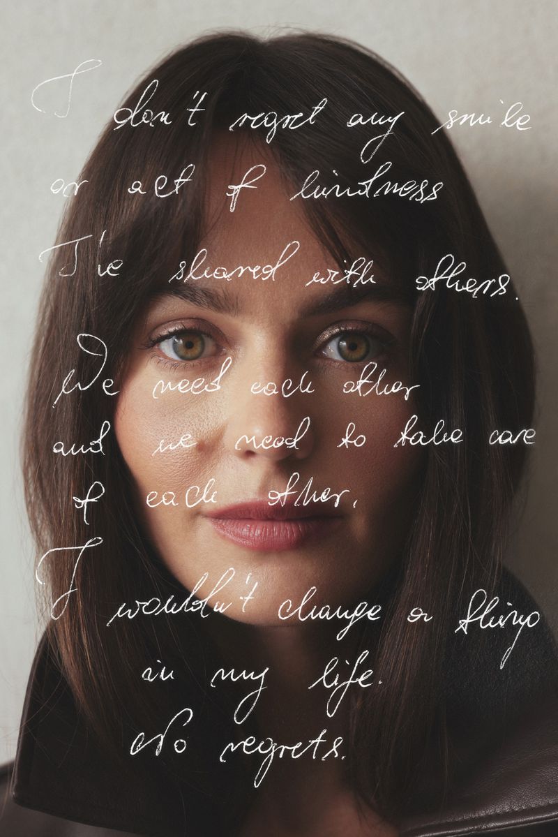 Close-up portrait of a woman with brunette hair, wearing a leather jacket, and covered with handwritten text. Neutral studio background.