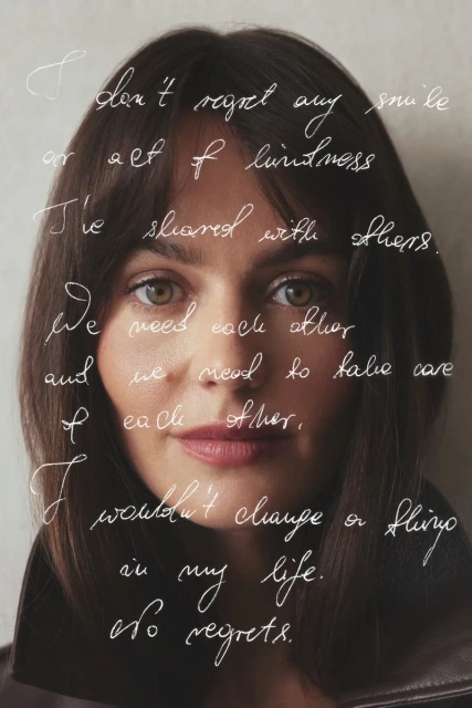 Close-up portrait of a woman with brunette hair, wearing a leather jacket, and covered with handwritten text. Neutral studio background.