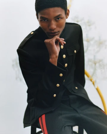 Model Lebo Malope wearing a black uniform jacket with gold buttons for Wales Bonner F/W 25