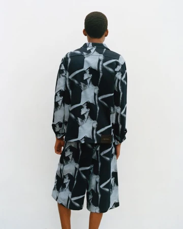 Model seen from behind wearing a patterned long-sleeve shirt and matching shorts against a white background