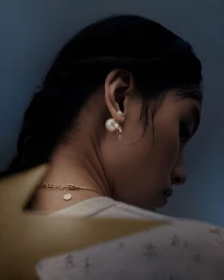 Close-up profile of model Tinglei Liu wearing pearl earrings and a delicate gold necklace for Dior Lunar New Year.