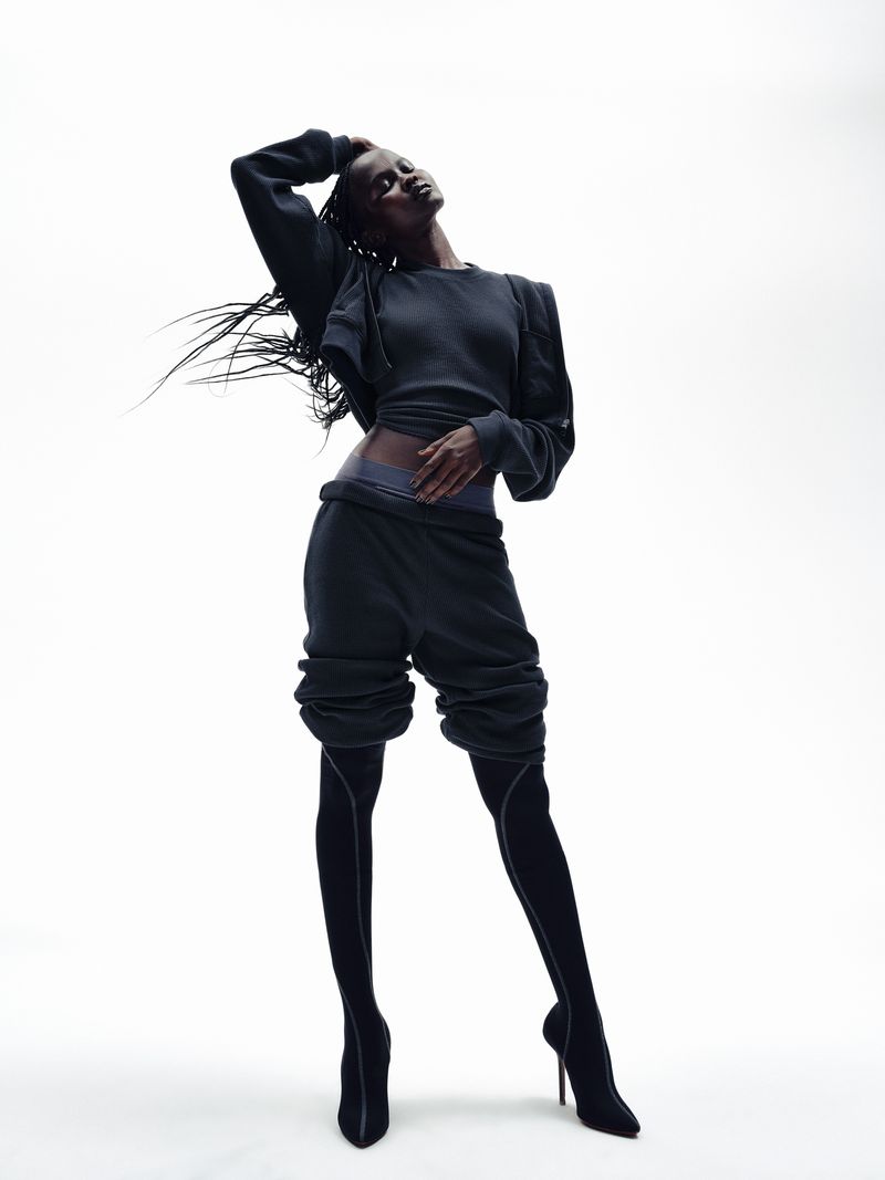 Model in dark waffle knit apparel and high boots against a white studio background for SKIMS Heavy Waffle project