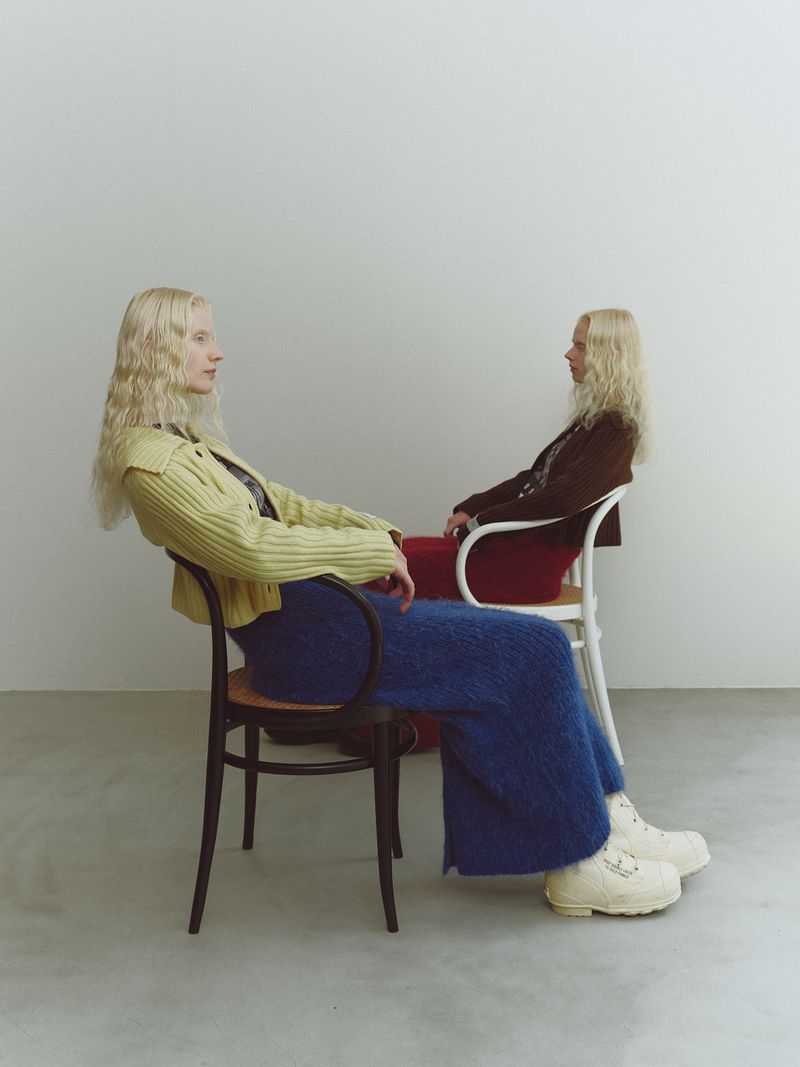 Two blonde models seated on chairs against a plain white studio wall for NIKO and SS25 lookbook photography by Masaya Tanaka.