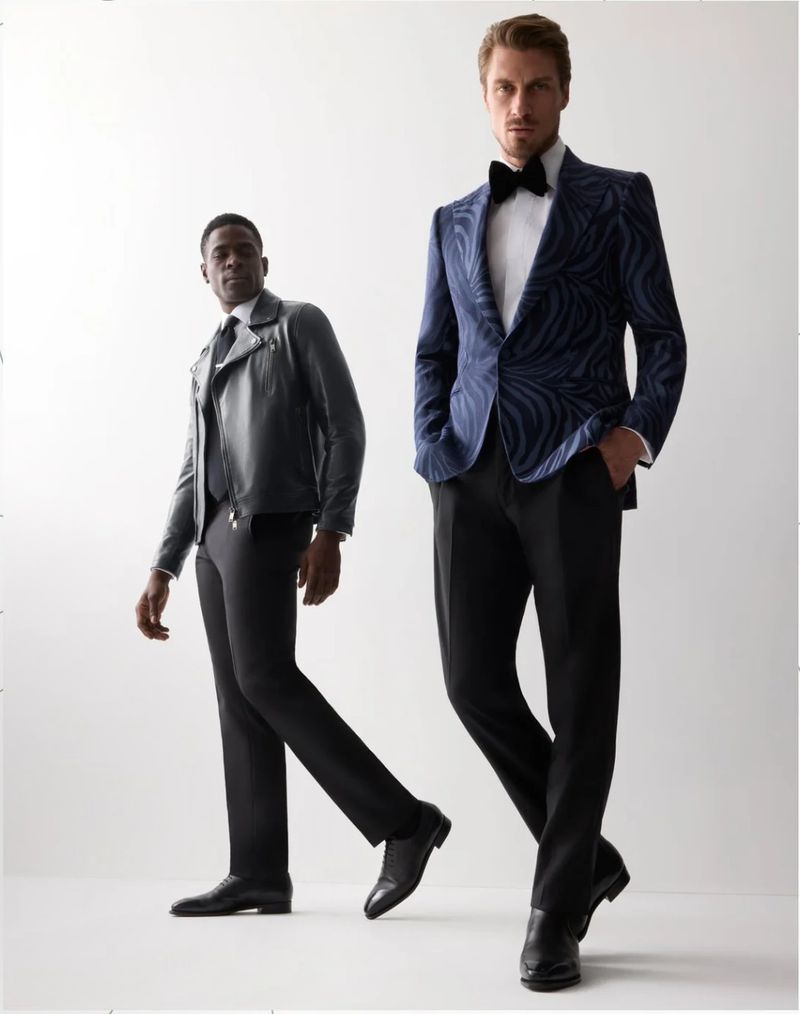 Two male models posing against a white background, one wearing a patterned blue blazer and black trousers