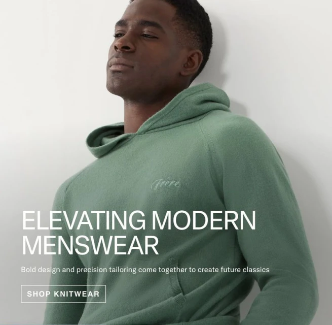 Studio shot of a Black male model wearing a hooded knit sweatshirt, showcasing modern menswear fashion against a neutral background.