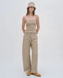 Model wearing a matching plaid strapless top and wide-leg trousers with a bucket hat against a white background.
