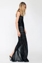 Model wearing a dark sequin maxi dress against a plain white studio background