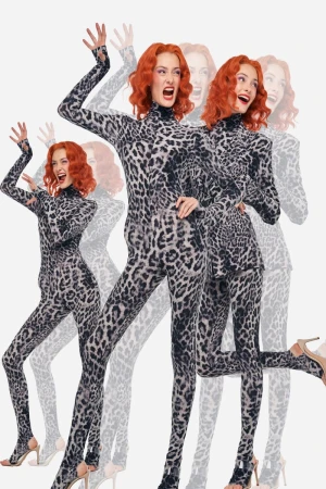 A woman with red hair poses in a grey leopard print catsuit and heels, against a bright white background, captured with dynamic, energetic poses.