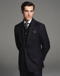Model Adam Sattrup in a black suit with patterned tie against a grey background for Dunhill photographed by Chris Lensz