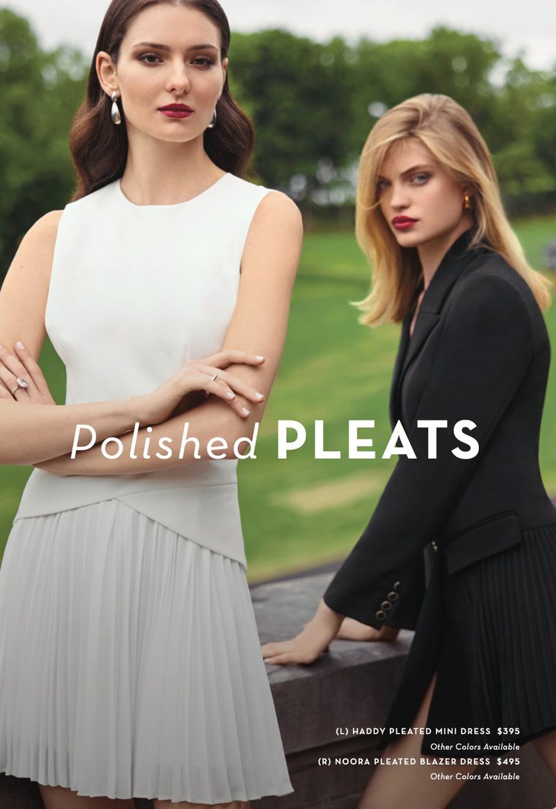 Two women model pleated dresses outdoors, one in a white mini dress, the other in a black blazer dress, set against a blurred green backdrop.