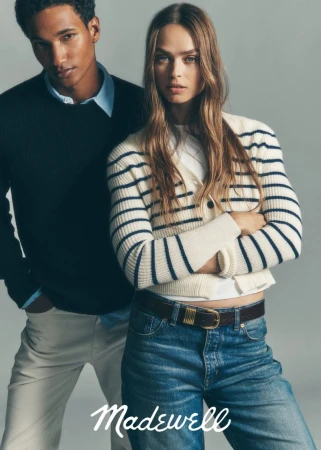 Fashionable couple wearing Madewell clothing, woman in striped cardigan and jeans, man in sweater and pants, studio shot.