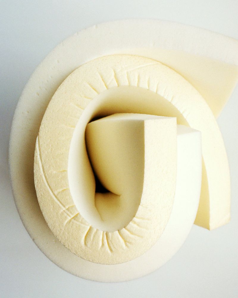Close-up studio shot of rolled up foam showcasing its texture and shape, set against a plain white background.
