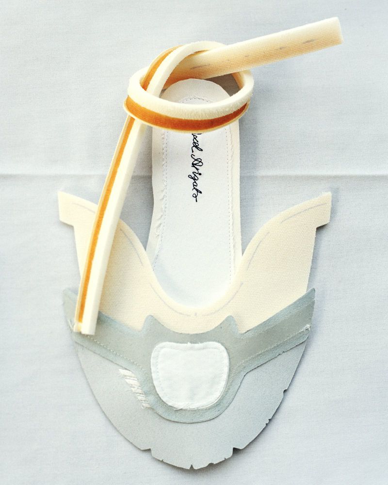 White mule sandal with a tan velvet strap knotted at the toe, studio shot. Fashion-forward footwear for the modern woman, stylish and chic.