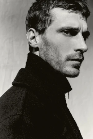 Close-up profile portrait of model Clement Chabernaud wearing a dark high-collared jacket for Zara Man shot by Alvaro Perena Jimenez.