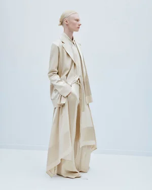 Model in a cream blazer and matching trousers standing against a plain white background for the Joseph Spring Summer 2025 lookbook.
