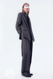Model wearing a grey tailored blazer and wide-leg trousers against a clean white background