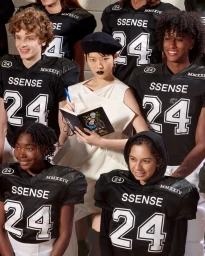 Group of models posing in black football jerseys alongside a woman holding a notebook for SSENSE FW24 Emerging Brands project.