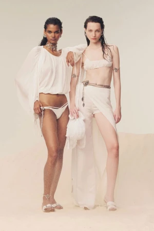 Two female models in white resort wear posing together against a pale sandy background for Blumarine Spring Summer 2025 lookbook.
