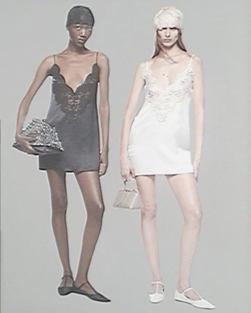 Two female models posing in mini slip dresses against a grey background for The Attico S/S 25 collection.
