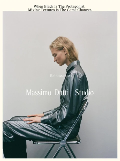 Adult woman in metallic silver shirt and pants sitting on a transparent chair in a light studio setting. Fashion editorial shot.