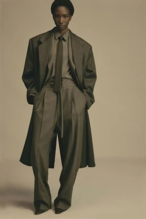 Model in oversized grey blazer suit and matching tie against a neutral background for Fear of God F/W 25 Men's Lookbook