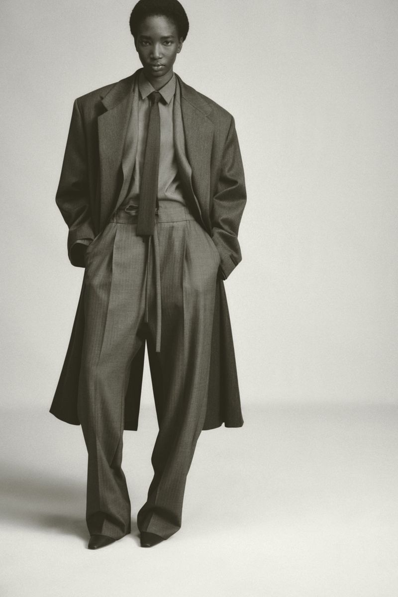 Model wearing an oversized suit and tie against a plain light studio background for Fear of God
