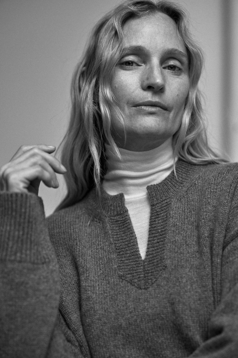 Monochrome portrait of model Amy Wesson wearing a grey knit sweater and white turtleneck in The Autumn Edit.