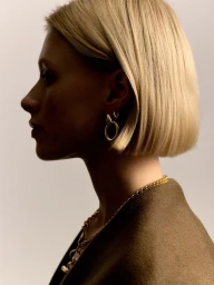 Profile portrait of a blonde woman wearing gold hoop earrings and a gold chain necklace for Tilly Sveaas